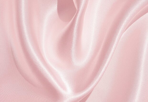 Smooth pink satin fabric texture with elegant satin folds