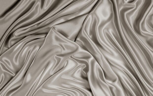 Smooth satin fabric texture with elegant folds and shiny surface