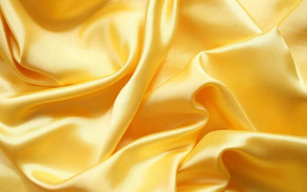 Smooth yellow satin fabric with elegant folds and shiny texture