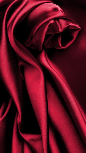 Smooth red satin fabric textile with elegant folds and shine