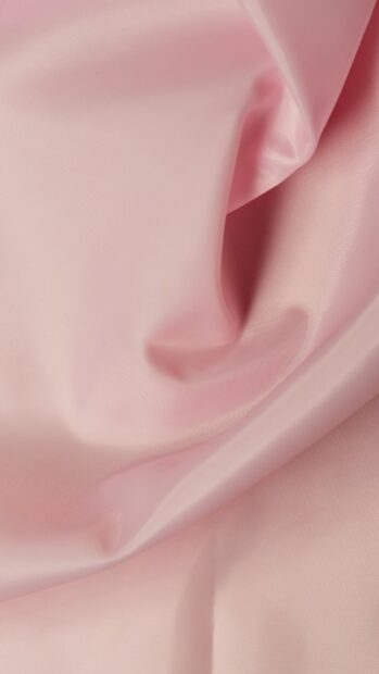 Soft pink satin fabric with smooth folds and delicate texture