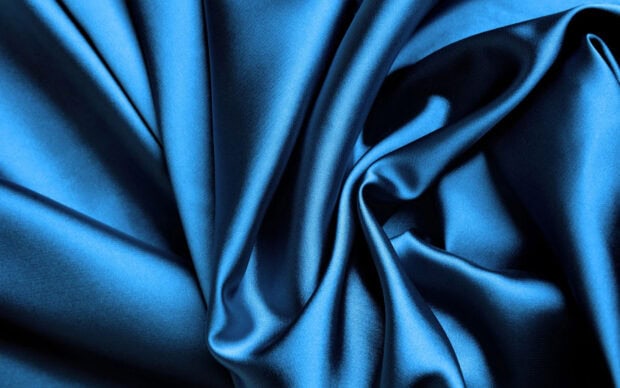 Smooth blue satin fabric with elegant folds and rich texture