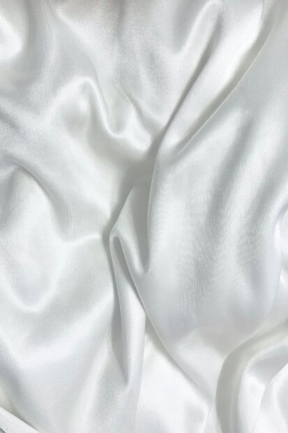 Smooth satin fabric texture with white silky folds and soft highlights