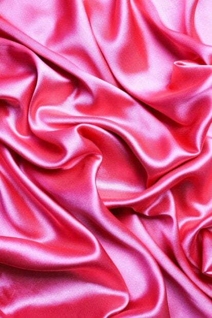 Soft pink satin fabric with smooth texture and elegant folds