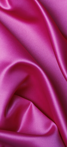 Smooth pink satin texture with folds and soft light reflections