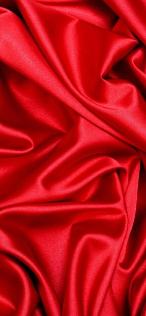 Smooth red satin fabric texture with soft folds and luxurious shine
