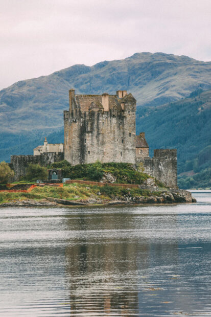 Ancient stone castle surrounded by water and hills in Scotland