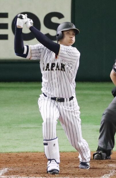 Shohei Ohtani in Japan baseball uniform swinging the bat during a game