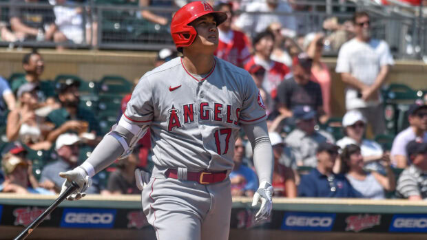 Shohei Ohtani in Angels uniform holding a bat on the baseball field during a game