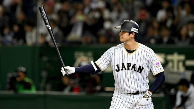 Shohei Ohtani preparing to bat during a Japan baseball game in a striped uniform