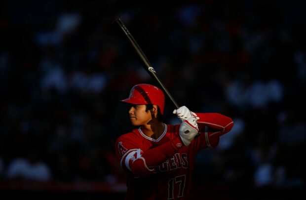 Shohei Ohtani preparing to bat in a baseball game wearing a red Angels uniform number 17