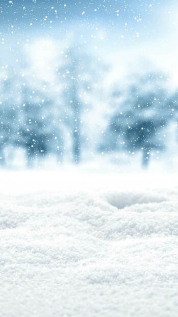 Soft snowfall covering snowfield with blurred trees in winter