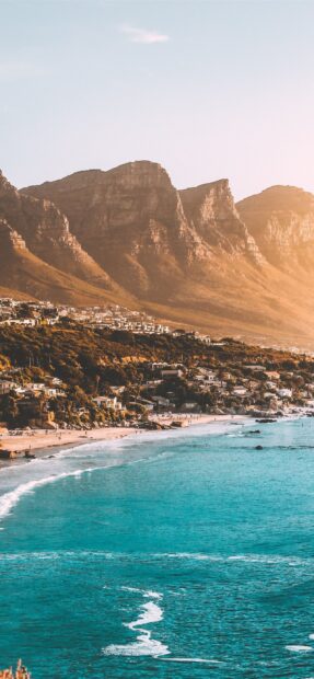 Coastal view of South Africa with mountains and turquoise sea at sunset