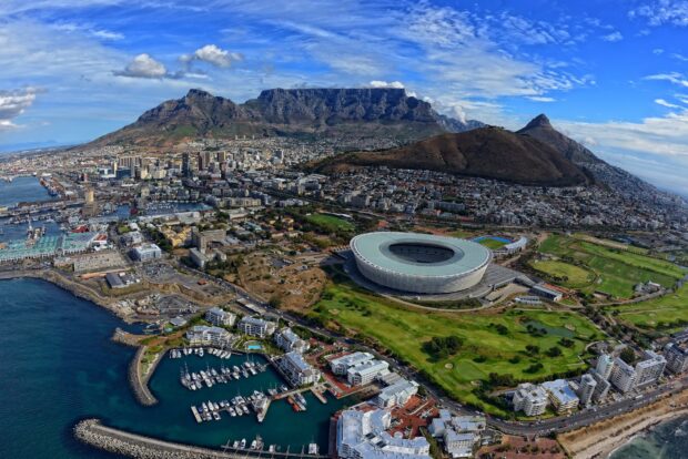 A panoramic view of South Africa cityscape with Table Mountain and stadium in clear sky