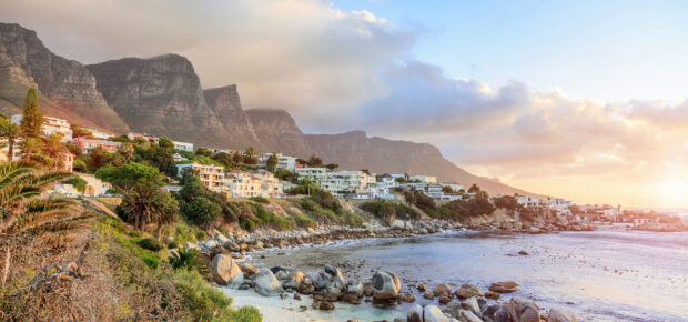 Coastal landscape of South Africa with mountains and houses at sunset