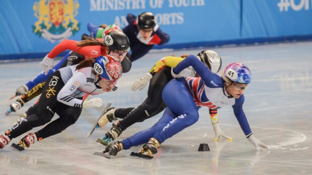 Female athletes competing in a speed skating race on ice rink