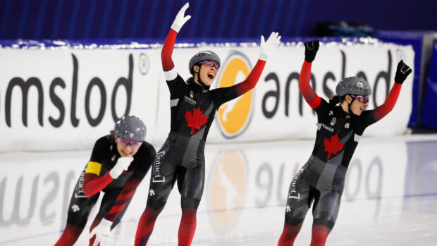 Female speed skaters celebrating a win on ice during a speed skating competition