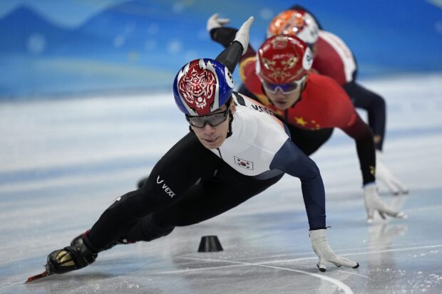 A speed skater from South Korea competing in a high speed race on ice