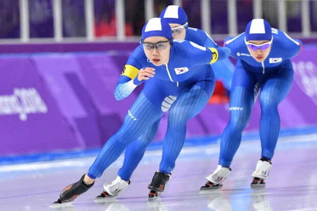 South Korean speed skating team competing in a race wearing blue suits