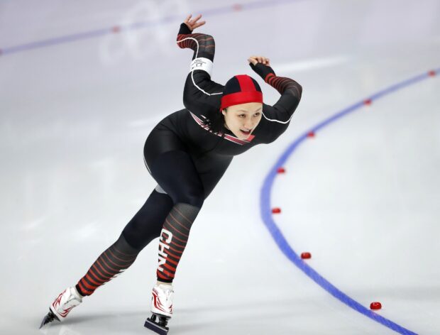 Female athlete skating fast on ice displaying speed skating technique