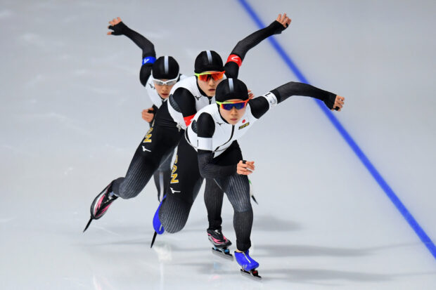 Japanese speed skating athletes competing on ice during a race