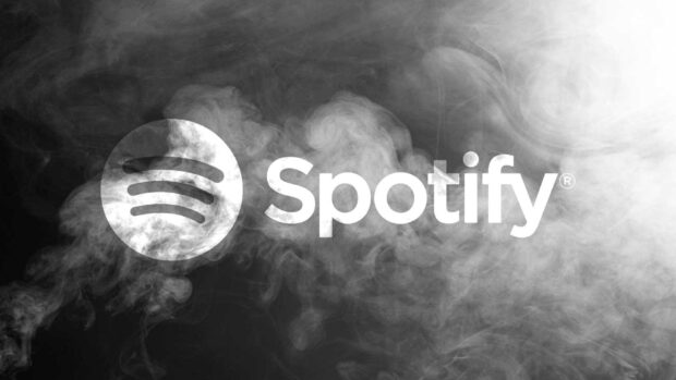 White Spotify logo surrounded by smoke on a black background featuring Spotify
