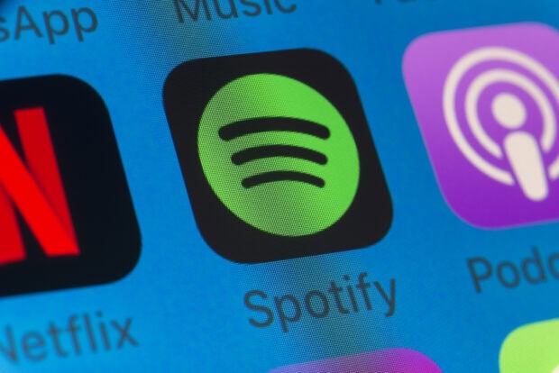Close up of Spotify app icon on a phone screen showing the music streaming platform