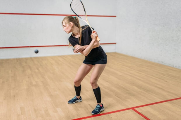 Female squash player preparing to swing on the court during a squash match