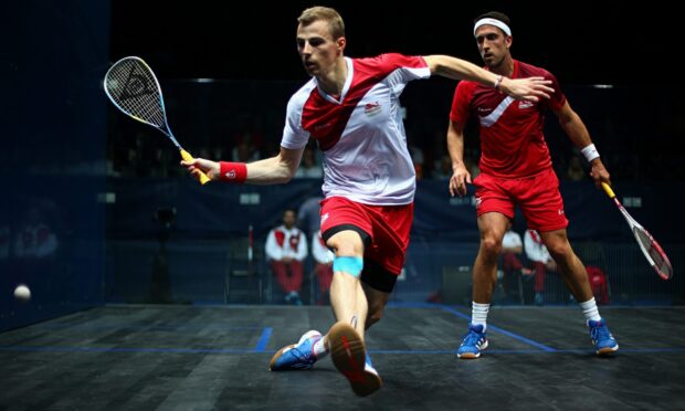 Two squash players in action on court during a squash sport match