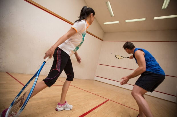 Two squash players competing on the court during an intense match