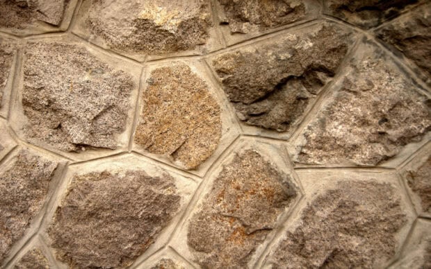 Rough stone texture with natural patterns and earthy tones on wall surface