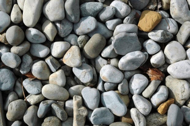 Smooth stone texture with various gray and brown tones on outdoor ground surface
