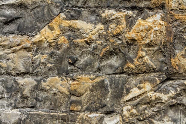 Rough stone texture with various natural colors and detailed cracks on the surface
