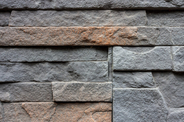 Rough stone texture with various shapes and patterns on a wall surface