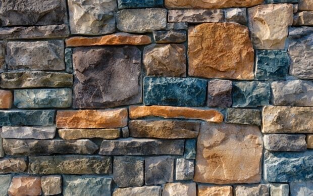 A close up view of diverse stone texture in various colors forming a sturdy wall