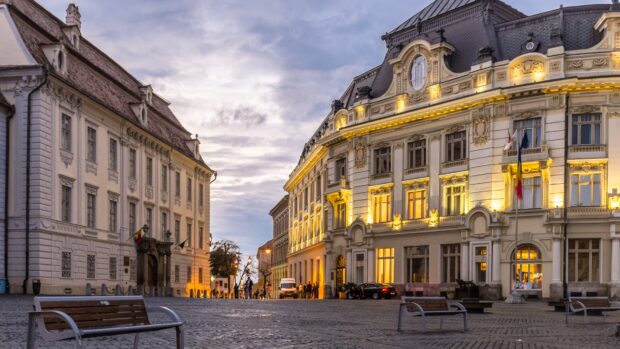 Historic town buildings illuminated at dusk in the town square