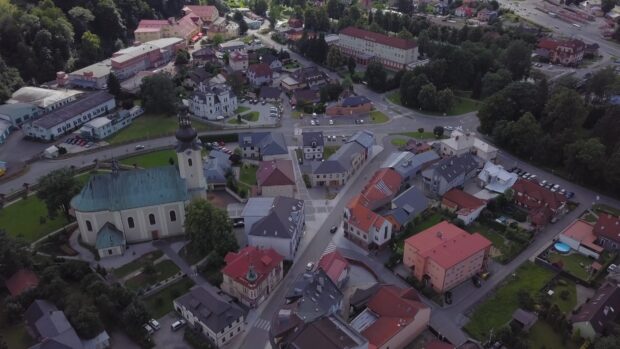 Aerial view of town with houses and church surrounded by greenery
