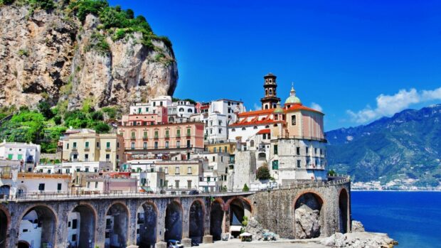 A picturesque town built on cliffs near the sea with colorful buildings and clear blue sky