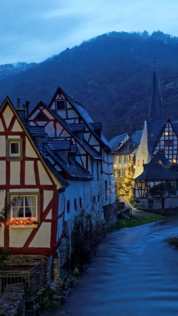 Traditional town with timber framed houses by the river during twilight