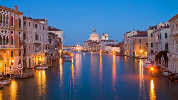 Venice canal view with historical buildings and dome during twilight in Venice
