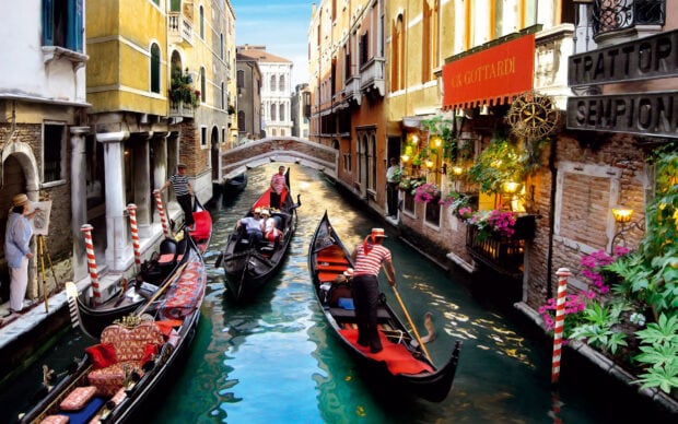 Gondolas floating through the Venice canal with historic buildings lining the waterway