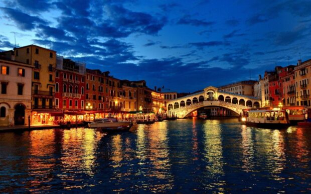Night view of Venice bridge and buildings reflecting on water at dusk