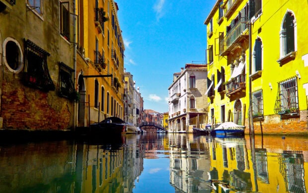 Colorful Venice canal with historic buildings reflecting on calm water