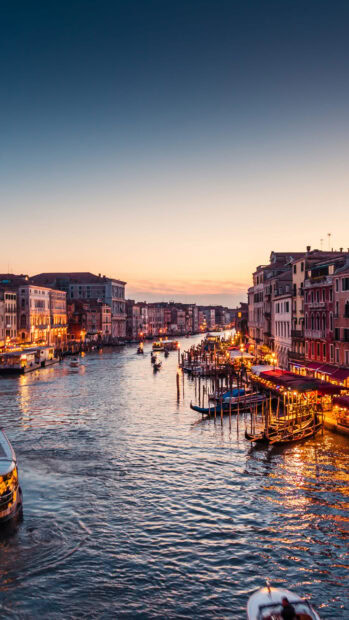 Venice canal with gondolas and historic buildings at sunset in Venice