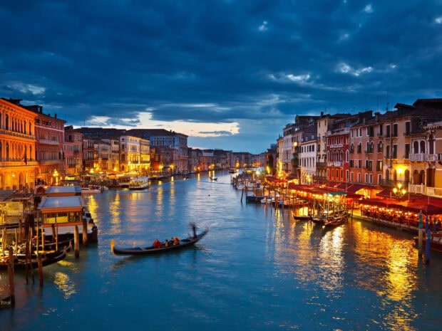 Evening canal scene showcasing Venice with historic buildings and gondolas
