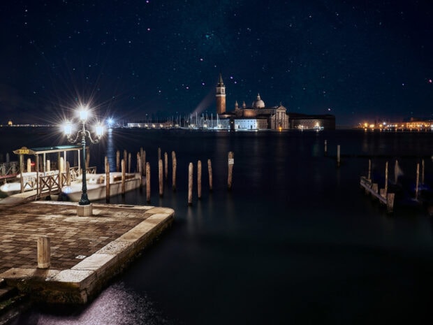 Night view of Venice canal with illuminated lampposts and historic buildings