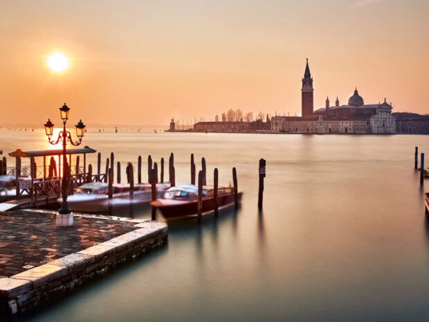 Venice cityscape with boats and historic buildings at sunset