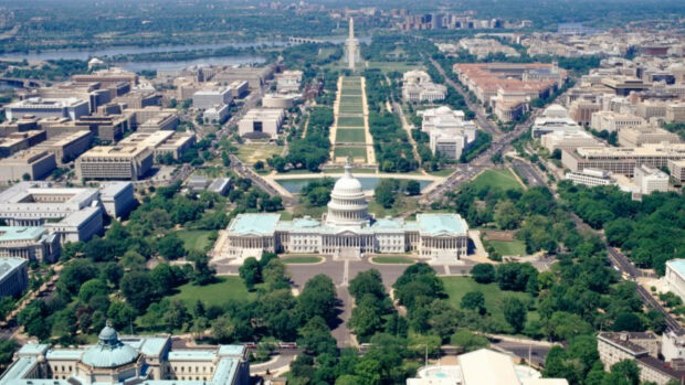 Aerial view of Washington Dc with the Capitol building and National Mall surrounded by cityscape and greenery