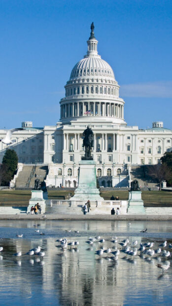 Statue and Capitol building in Washington Dc under clear blue sky