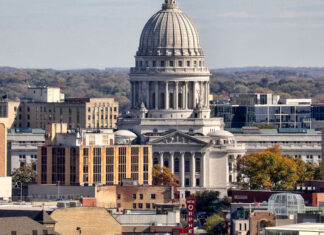 The Wisconsin State Capitol building surrounded by autumn trees in the cityscape of Madison